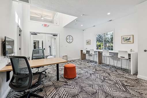 A room with a black chair and a patterned carpet.