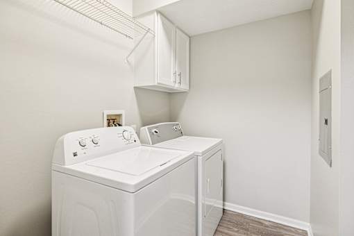 A white washing machine and dryer in a small laundry room.
