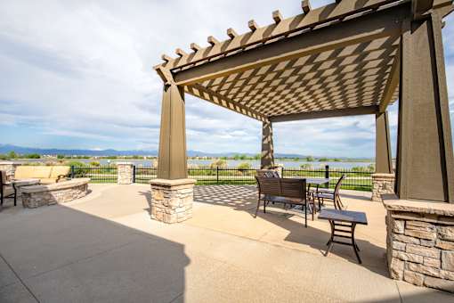 a patio with a pergola and a view of the water