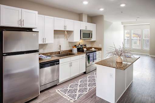 an open kitchen with stainless steel appliances and white cabinets