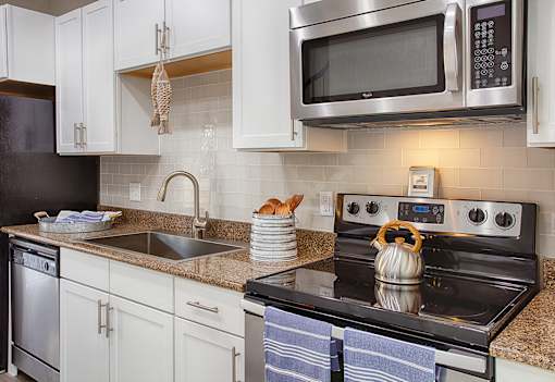 a kitchen with stainless steel appliances and white cabinets