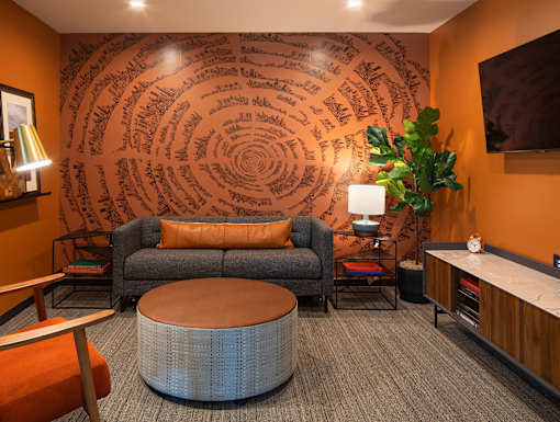 a living room with orange walls and a gray couch