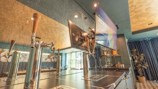 A modern bar with a stainless steel counter and a wooden tap.