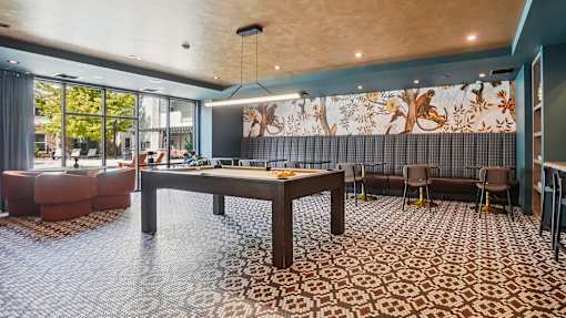 A room with a patterned carpet and a large table with chairs.