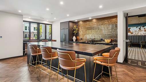 A modern kitchen with a bar area and chairs.