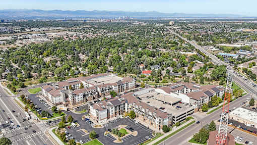 A large building complex with a parking lot in front of it.
