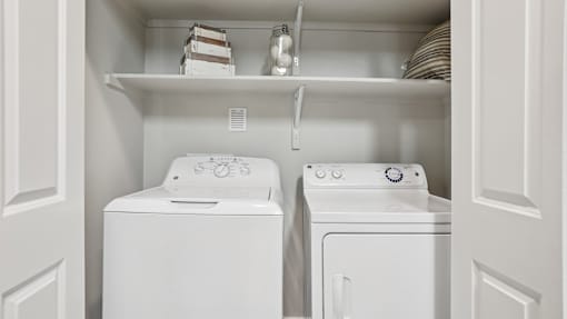 A white washing machine and dryer in a laundry room.