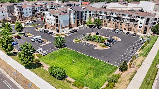an aerial view of an empty parking lot in front of an apartment building