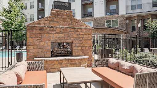 a courtyard with a stone fireplace and tables and chairs