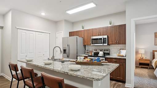 a kitchen with a granite counter top and a stainless steel refrigerator