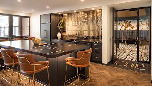 a kitchen with a large island and a bar with chairs
