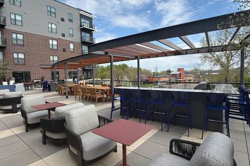 A patio with tables and chairs and a building in the background.