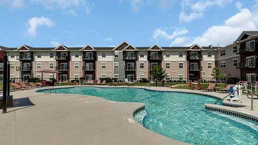 a swimming pool with an apartment building in the background