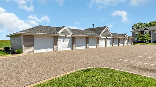a house with white garage doors and a driveway in front of it