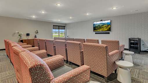 a meeting room with chairs and a television on the wall