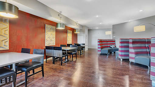 a dining room with tables and chairs in front of a red wall