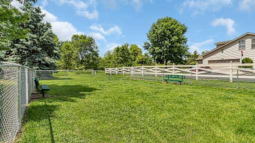 a fenced in backyard with a white fence and benches