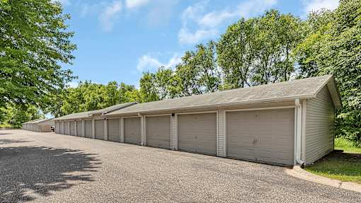 a row of garages in a parking lot with trees