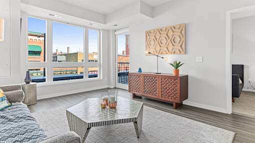 a living room with a couch and a coffee table and large windows