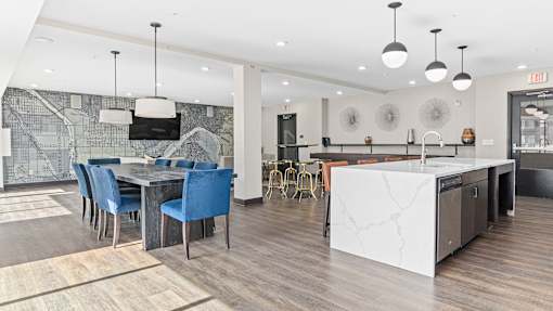a kitchen and dining area with a marble island and blue chairs