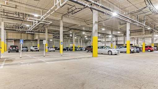 a parking garage with cars parked in it and yellow pillars