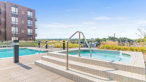 a pool and spa with a building in the background