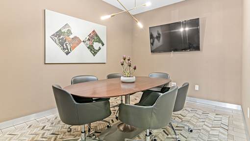 a conference room with a table and chairs and a tv
