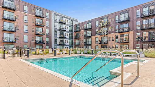 a swimming pool with an apartment building in the background