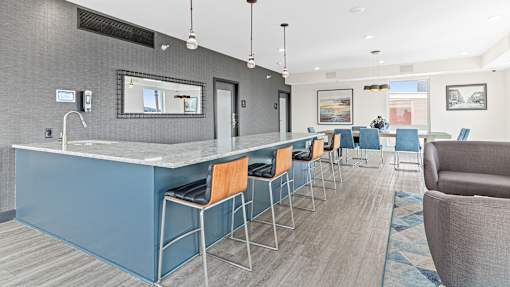 a communal bar with blue stools in a hotel lobby