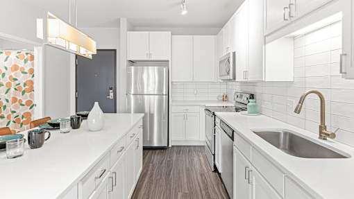 a kitchen with white cabinets and a stainless steel refrigerator