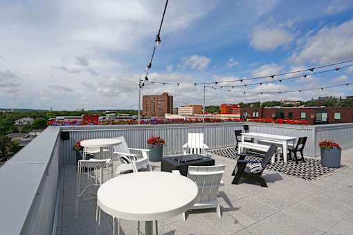 Stunning rooftop with string lights, casual dining area, and lounge seating.