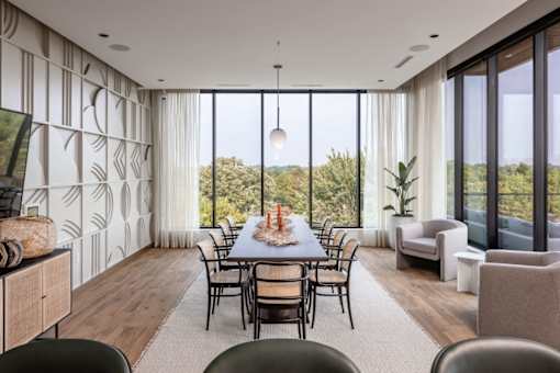 a dining room with a long dining table and a large window