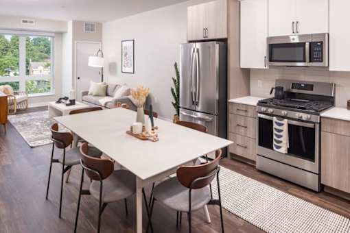 an open kitchen and living room with a dining table and chairs
