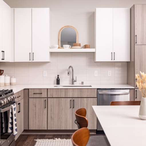 a kitchen with white cabinets and a white table and chairs