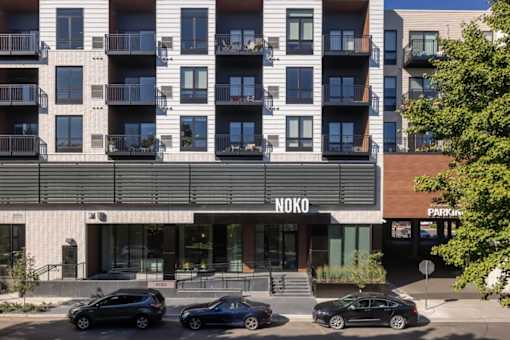 an apartment building with cars parked in front of it