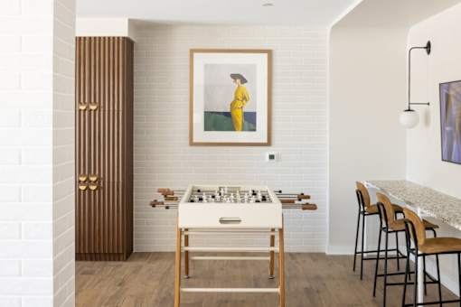 a room with a foosball table and a painting on the wall