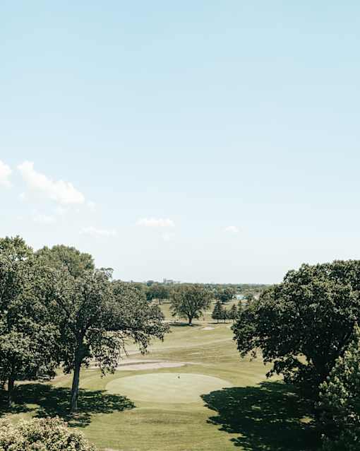 a view of a golf course from the top of a hill