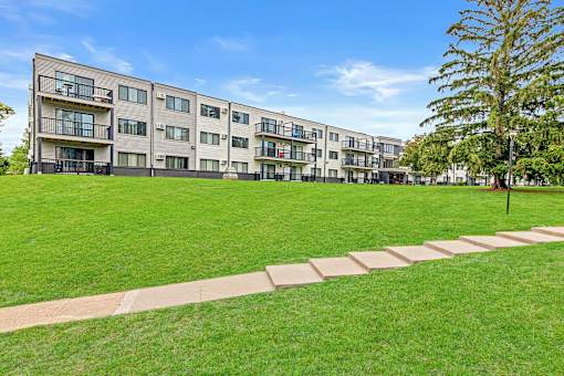 A large grassy area in front of apartment buildings.