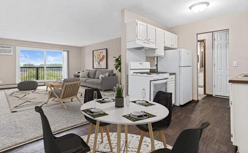 A modern kitchen with white appliances and a dining table set for two.