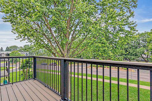 A tree is in the background of a balcony.