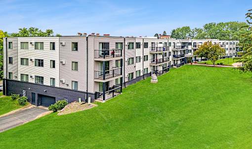 Apartment complex with green grassy area in front.