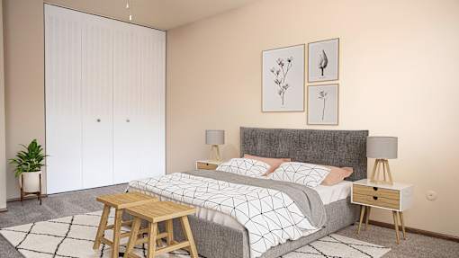 A bedroom with a bed, nightstands, and a plant.