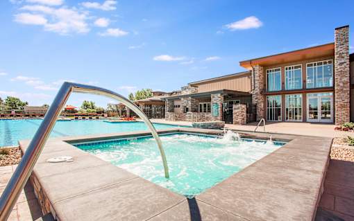 Outdoor hot tub next to outdoor pool, with long curved railing