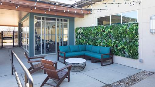 A patio with a sofa, chairs, and a table.