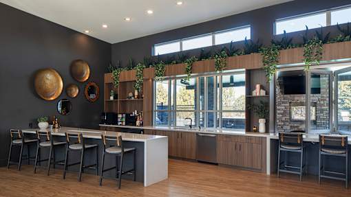 A bar area with a long counter and chairs.