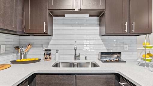 a white kitchen with wooden cabinets and a sink