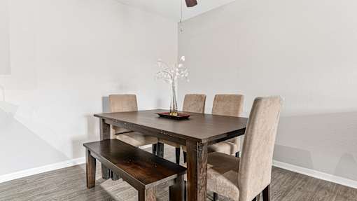 a dining room with a wooden table and chairs