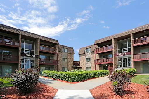 Exterior view of Plymouth Pointe building with split concrete walk path