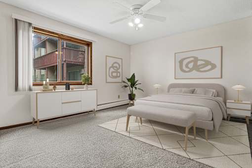 A bedroom with a large bed, a dresser, and a ceiling fan.