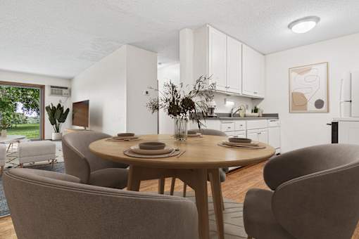 A modern dining room with a round table and grey chairs.